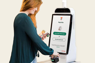 Customer using a 7-Eleven self-serve kiosk to pay for items in-store with their phone